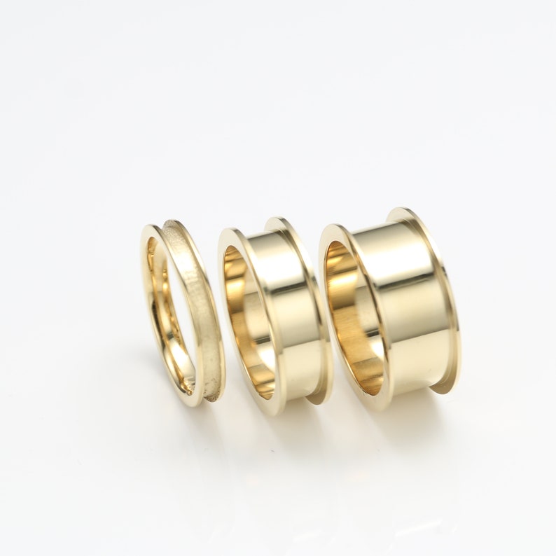 May include: Three gold rings of different sizes, stacked together. The rings are smooth and shiny.