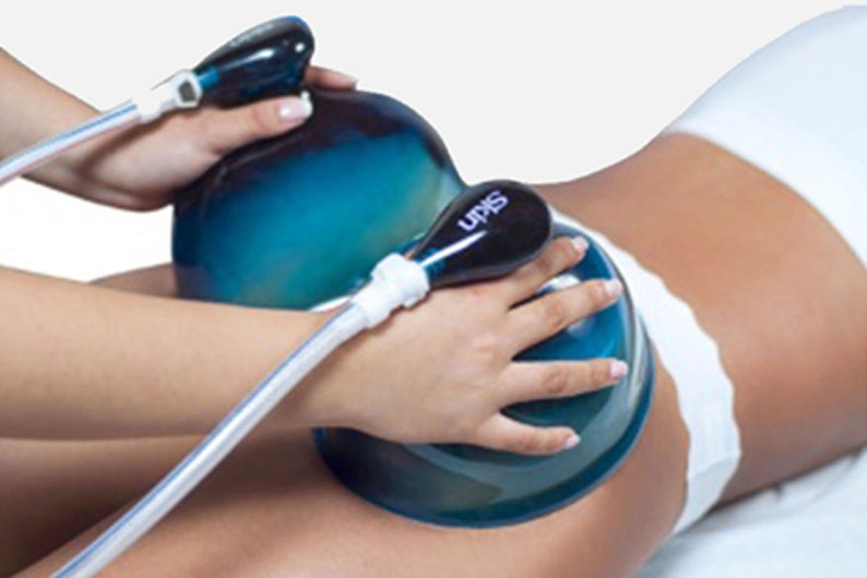 May include: A person using a blue and white suction cup device for a body treatment. The device has the word "SKIN" printed on it.