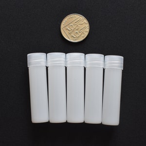 May include: Five white plastic bottles with screw-on caps. The bottles are about the size of a US dime.