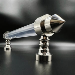 May include: A silver handrail with a clear acrylic tube and a pointed end cap. The handrail has a decorative base with a fluted design.