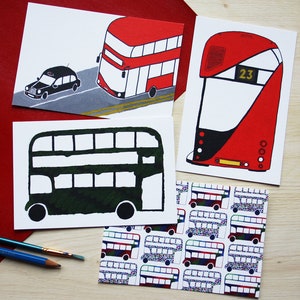 Può includere: Quattro cartoline con illustrazioni di autobus a due piani di Londra e un taxi nero. Le cartoline sono bianche con contorni neri e presentano colori rosso, verde e nero. Una cartolina ha il numero 23 sull'autobus.