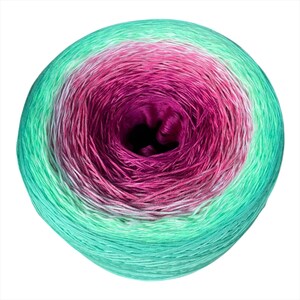 May include: A round ball of yarn featuring a gradient color transition. The center is a deep magenta, which shifts outward through shades of light pink and white, finally transitioning into a vibrant mint green at the outer edges of the yarn cake.