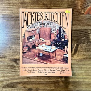 May include: A vintage book titled "Jackie's Kitchen Volume II" featuring a miniature kitchen scene. The cover displays a detailed diorama of a kitchen with furniture and appliances. The book includes instructions, patterns, and diagrams for miniature projects.