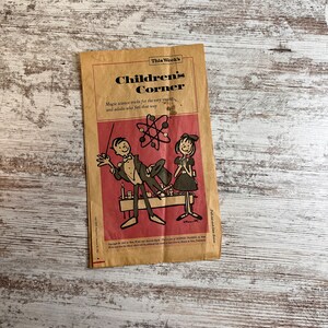 May include: A vintage newspaper clipping with the headline "This Week's Children's Corner". The clipping features a cartoon illustration of a magician performing a magic trick for a young girl. The text below the illustration reads "Magic science tricks for the very young, and adults who feel that way."