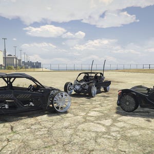 May include: Three black off-road vehicles are parked on a concrete surface under a cloudy sky. The vehicles have large, custom wheels. The Can-Am vehicle has the brand name visible on the side.