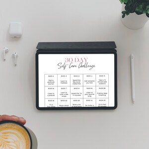 May include: A digital tablet displaying a 30-day self-care challenge with daily activities such as starting a gratitude journal, learning to meditate, spending the day social media free, calling someone you love, taking a 15-minute walk outdoors, listening to a podcast, learning to cook a new recipe, listening for 15 minutes to your favorite song, practicing deep breathing, trying a free online class, reading a book, writing a list, de-cluttering a drawer, and going to bed 30 minutes earlier.
