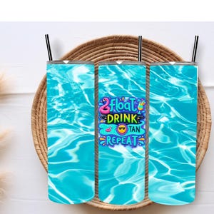 May include: Three tall, insulated tumblers with black straws. The tumblers feature a vibrant turquoise water design. One tumbler has the text "Float Drink Tan Repeat" with a flamingo, sunglasses, and cocktail graphics. The tumblers are on a woven tray.