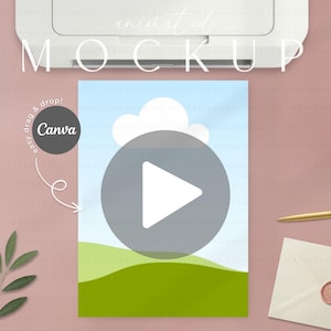 Op de afbeelding: Een mockup met een Canva-ontwerp met een afspeelknop-overlay. Het ontwerp omvat een landschap met groene heuvels, blauwe lucht en witte wolken. De afbeelding staat op een roze oppervlak met een printer, pen en envelop.