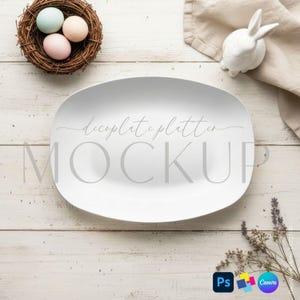 May include: A white oval serving platter with the text "decoplate platter MOCKUP" is the focal point. A small nest with three pastel eggs, a white ceramic bunny, and a sprig of lavender are arranged on a light wood surface.