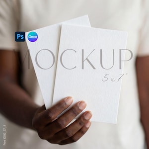 Puede incluir: Dos tarjetas blancas en blanco de 12,7 x 17,8 cm se sostienen en la mano de una persona. La palabra "MOCKUP" está impresa en gris en las tarjetas. Los logotipos de Canva y Photoshop están en la esquina superior izquierda.