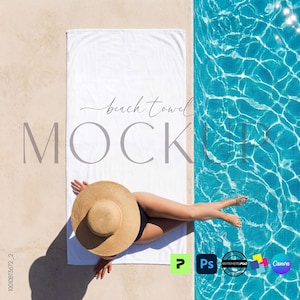 May include: A white beach towel mockup with the words "beach towel MOCKUP" in a stylish font. A person wearing a straw hat and a black swimsuit is lying on the towel next to a pool of blue water. The image has a bright, summery feel.