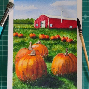 May include: Watercolor painting of a red barn with a field of orange pumpkins in front of it. The sky is blue with white clouds.