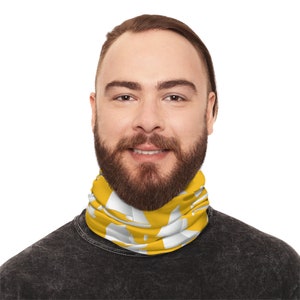 May include: A man wearing a yellow and white neck gaiter with a sailboat pattern. The gaiter is made of a soft, breathable fabric and is perfect for outdoor activities.