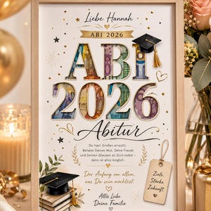 Könnte beinhalten: Ein gerahmter Abschlussdruck mit dem Text 'Liebe Hannah ABI 2026', wobei die großen Buchstaben und Zahlen mit Euro-Banknotenmustern gefüllt sind. Es enthält eine schwarze Doktorhut-Applikation, Bücherstapel und ein Holzschild mit 'Ziele. Stärke. Zukunft.'