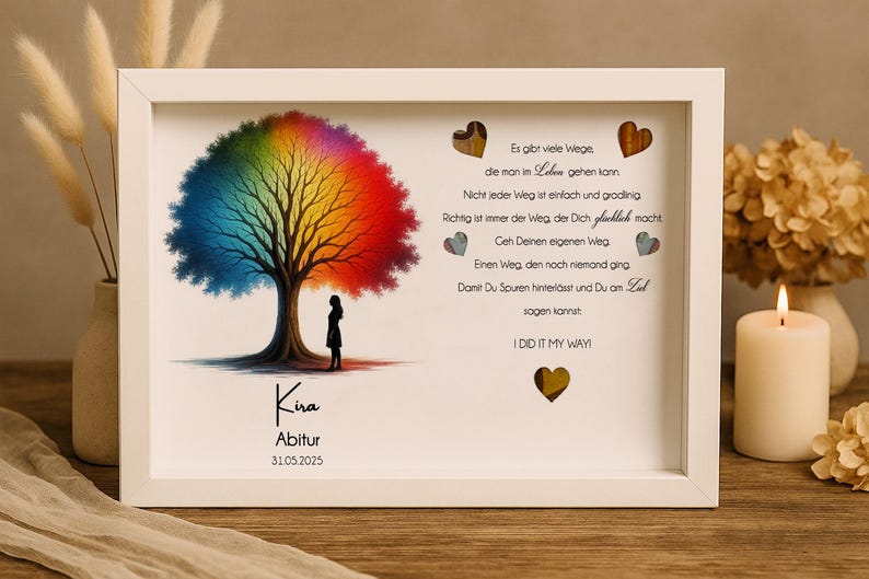 May include: A white framed picture with a rainbow tree and a quote about finding your own path. The quote reads, "Es gibt viele Wege, die man im Leben gehen kann. Nicht jeder Weg ist einfach und gradlinig. Richtig ist immer der Weg der dich gl&uuml;cklich macht. Geh deinen eigenen Weg. Einen Weg, den noch niemand ging. Damit du Spuren hinterl&auml;sst und du am Ziel sagen kannst: I DID IT MY WAY!" The picture also includes the text "Kira Abitur 31.05.2025".