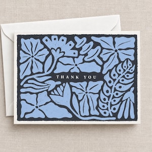 K&ouml;nnte beinhalten: Eine rechteckige Gru&szlig;karte mit dunkelgrauem Hintergrund und hellblauen Blumenillustrationen. Der Text THANK YOU ist in Wei&szlig; in der Mitte aufgedruckt. Die Karte wird mit einem schlichten wei&szlig;en Umschlag geliefert, was ein klares Set ergibt.