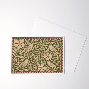 Puede incluir: Una tarjeta de felicitaci&oacute;n rectangular con un fondo verde oliva oscuro y un patr&oacute;n repetitivo de p&aacute;jaros, flores y ramas con hojas en color rosa claro. El dise&ntilde;o est&aacute; enmarcado por un borde de peque&ntilde;os puntos rosas e incluye un sobre blanco.