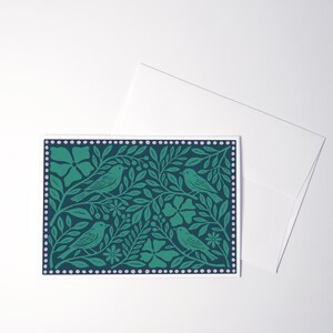 Puede incluir: Una tarjeta de felicitaci&oacute;n rectangular con un fondo verde azulado oscuro y un patr&oacute;n repetitivo de cuatro p&aacute;jaros posados entre hojas, tallos y flores verdes. El dise&ntilde;o est&aacute; rodeado por un borde de peque&ntilde;os puntos de color rosa claro.