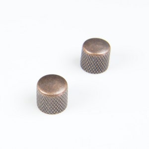 May include: Two copper-coloured guitar knobs with a knurled pattern.