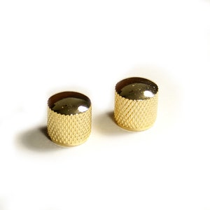 May include: Two gold-coloured guitar knobs with a diamond pattern.