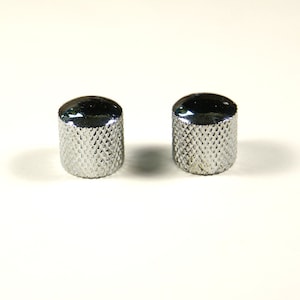 Puede incluir: Dos pomos de metal plateado con un patrón de diamante.