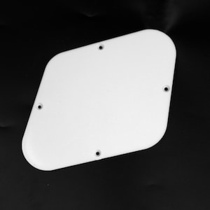 Puede incluir: Golpeador de guitarra blanco en blanco de plástico con cuatro agujeros para tornillos.
