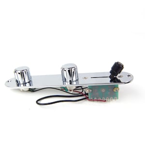 May include: Chrome guitar control plate with three knobs and a toggle switch. The plate is wired with a circuit board and wires.