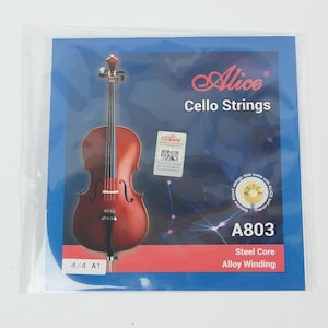 May include: A package of Alice Cello Strings, model A803, featuring a cello illustration. The packaging is blue with the brand name and product details. The strings are steel core with alloy winding. The cello illustration is a reddish-brown color.