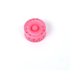May include: A pink plastic knob with black numbers 1 through 10 printed around the edge.