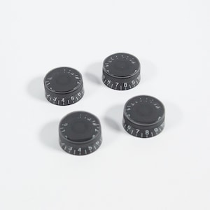 May include: Four black guitar knobs with white numbers 1 through 10.