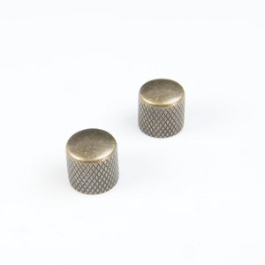 May include: Two antique gold-colored guitar knobs with a diamond pattern.