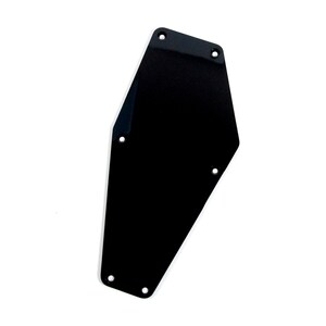 May include: A black, glossy, guitar backplate with five screw holes. The plate has a unique, angular shape and is set against a white background. The plate is a replacement part for a guitar.