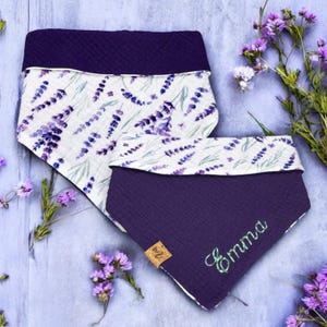 Könnte beinhalten: Zwei lila und weiße Hundehalstücher mit einem Lavendel-Blumendruck. Das kleinere Halstuch hat den Namen "Emma" in grüner Farbe gestickt.