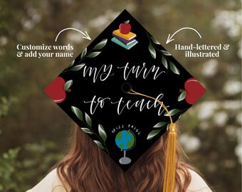May include: A black graduation cap with the words "my turn to teach" in white script. The cap features illustrations of apples, books, and a globe. A gold tassel hangs from the cap. The text "Customize words & add your name" is also present.