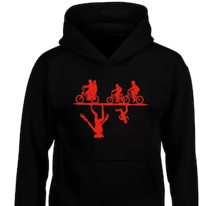 May include: Black hooded sweatshirt featuring a red graphic of four figures riding bicycles upside down. The figures are silhouetted and the bicycles are outlined in red.