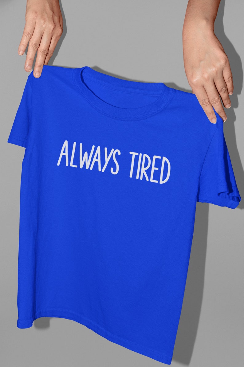 K&ouml;nnte beinhalten: Ein k&ouml;nigsblaues T-Shirt mit dem Aufdruck "ALWAYS TIRED" in Wei&szlig;.