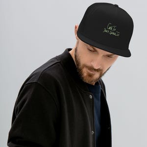 May include: Black mesh trucker hat with a black brim and a green embroidered design that says "Catch It, Don't Splash It".