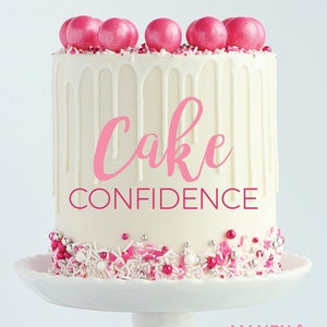 May include: A white cake with pink and white sprinkles and pink candy melts on top. The cake is on a white cake stand. The text "Cake Confidence" is written in pink on the cake. The text "SURE-FIRE RECIPES & TIPS for OVER-THE-TOP GORGEOUS CAKES" is written in black at the top of the image. The text "MANDY MERRIMAN" is written in pink at the bottom of the image.