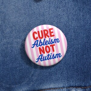 Può includere: Una spilla rotonda con uno sfondo a righe verticali rosa chiaro e bianco. Il testo CURE Ableism NOT Autism è stampato in un carattere sans-serif in grassetto, con le parole CURE e NOT in rosso e Ableism e Autism in blu.