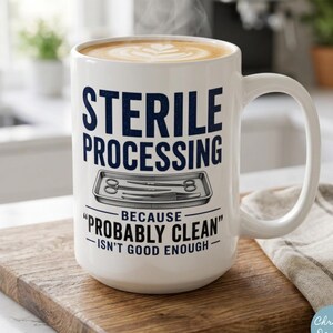 Könnte beinhalten: Ein weißer Keramikbecher gefüllt mit Kaffee und Latte-Art-Design. Der Becher zeigt den Text STERILE PROCESSING und BECAUSE PROBABLY CLEAN ISN'T GOOD ENOUGH sowie eine grafische Abbildung eines Metalltabletts mit chirurgischen Instrumenten.