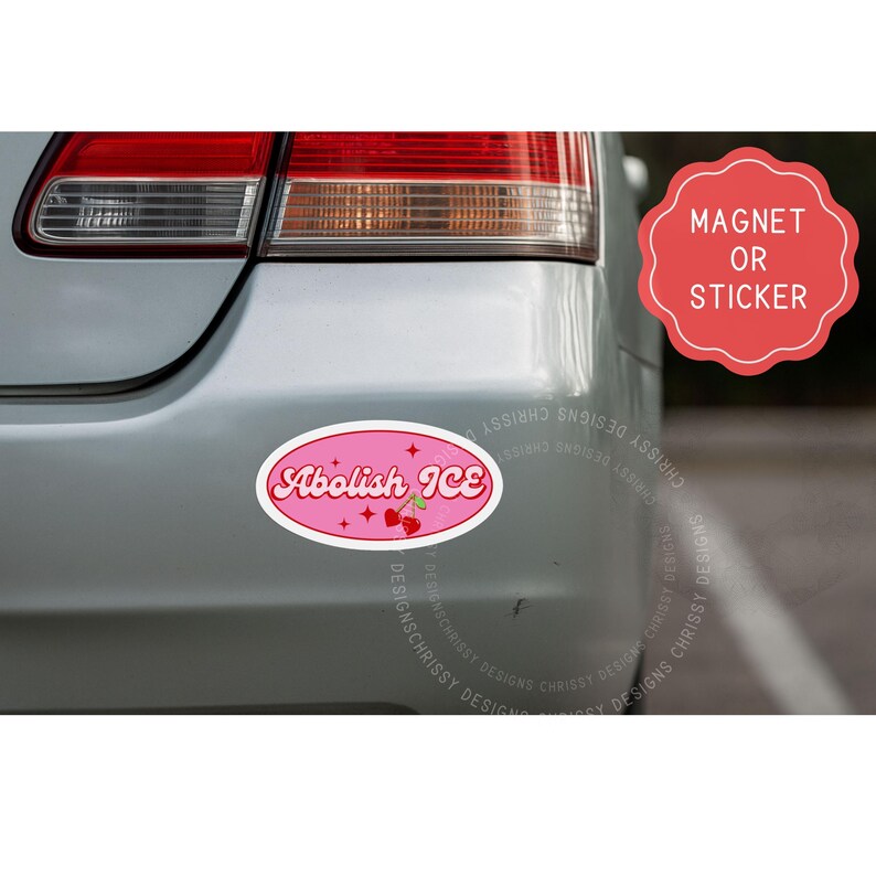 May include: Pink oval magnet or sticker with the text "Abolish ICE" in a retro font. The design includes cherries and stars. The magnet is attached to the back of a silver car.