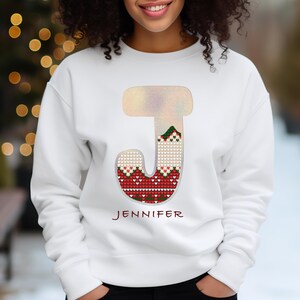 May include: White sweatshirt with a red, green, and white knit letter J. The letter is outlined in silver glitter. The name Jennifer is printed below the letter.