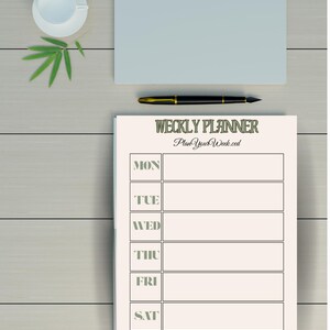 Könnte beinhalten: Ein Wochenplaner mit dem Text "WEEKLY PLANNER" und "PlanYourWeek.ced". Ein schwarz-goldener Stift, ein hellblauer Notizblock und eine weiße Teetasse mit Untertasse befinden sich ebenfalls auf der Holzoberfläche. Grüne Blätter liegen neben der Teetasse.