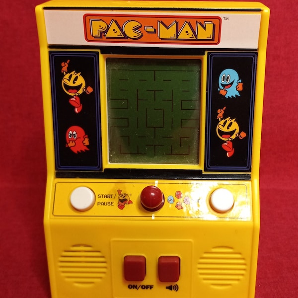 Retro handheld PAC-MAN game. Includes 2 AA batteries.  Very good condition.  Made by Bandai. Has 2 play modes- eat the dots and chase.