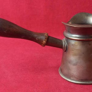 Metalen waterkoker met houten handvat
