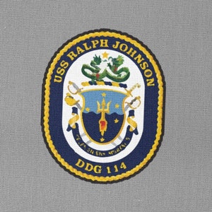 May include: A grey patch with a navy blue circle containing a crest with a green sea serpent, a trident, and a gold sword. The text "USS RALPH JOHNSON DDG 114" is written around the circle.