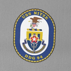 Può includere: Una toppa blu navy con un bordo di corda dorata e il testo "USS NITZE DDG 94". La toppa presenta uno stemma con un'aquila calva, uno scudo e un tridente.