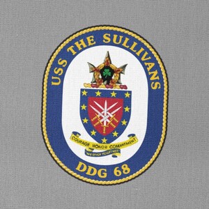 May include: A navy blue patch with a gold border and the text "USS THE SULLIVANS DDG 68" in white. The patch features a crest with a star, a sword, and the text "COURAGE HONOR COMMITMENT WE SERVE TOGETHER".