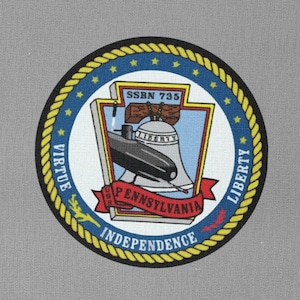 Könnte beinhalten: Ein marineblauer und goldener runder Patch mit weißem Hintergrund. Der Patch zeigt ein U-Boot, eine Glocke und den Text "SSN 735", "VIRTUE", "PENNSYLVANIA", "INDEPENDENCE" und "LIBERTY".