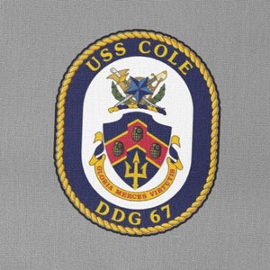 May include: A navy blue patch with a gold rope border and the text "USS COLE DDG 67". The patch features a crest with a shield, a trident, and crossed swords.
